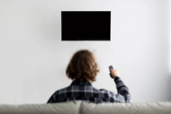 Tampilan Belakang Guy Menonton TV Switching Channels Di Rumah — Stok Foto