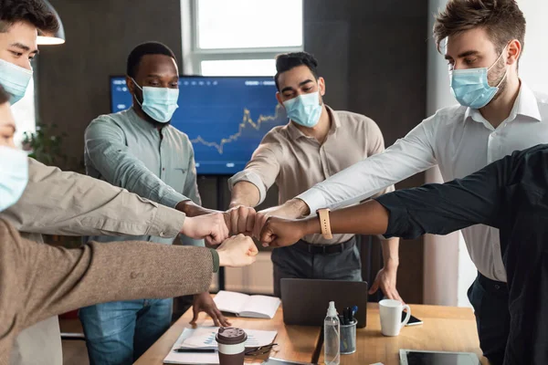 Portrait of diverse business people in masks giving fist bump — Stock Photo, Image