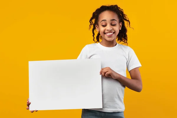 Schwarzes Mädchen mit leerer weißer Werbetafel im Studio — Stockfoto