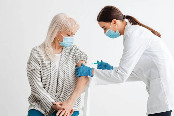 Senior vrouwelijke patiënt die wordt gevaccineerd tegen Covid-19 — Stockfoto