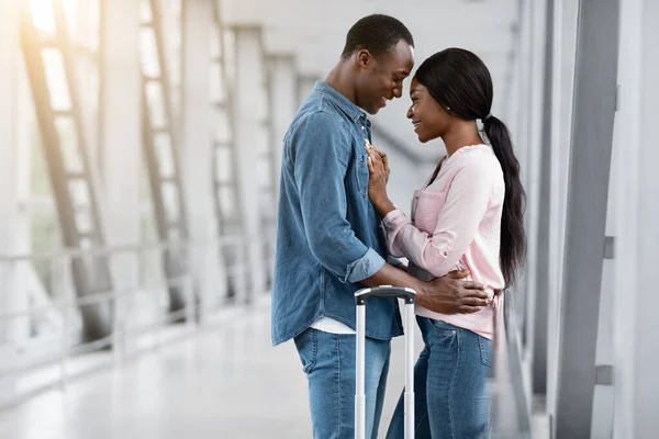 Retrato de pareja negra romántica abrazándose en la terminal del aeropuerto, esperando el vuelo —  Fotos de Stock