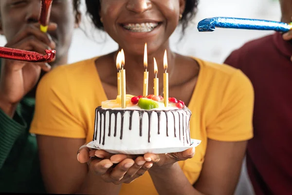 非洲裔美国妇女手中的生日蛋糕，与朋友一起庆祝 — 图库照片