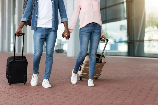 Viaje en pareja. Amantes negros irreconocibles caminando con maletas al aire libre cerca de la terminal del aeropuerto — Foto de Stock