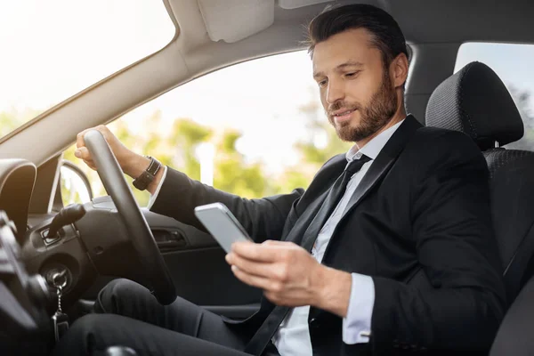 Snygg affärsman som kör bil, med mobiltelefon — Stockfoto