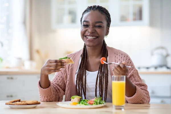 Inizio della giornata. felice nero donna mangiare prima colazione in cucina — Foto Stock