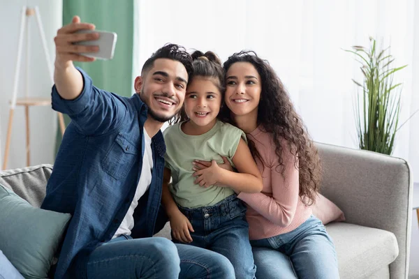 Glad arabisk familj av tre tar selfie med smartphone hemma — Stockfoto