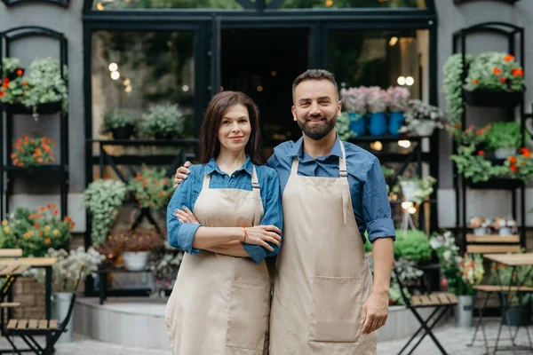 Shop and flower studio owners, waiters in eco cafe and greeting customers outdoor