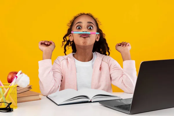 Retrato de sorrindo menina negra sentada na mesa fazendo lição de casa — Fotografia de Stock