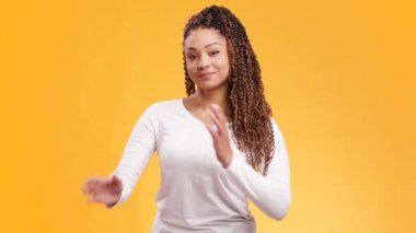 Beyaz gömlekli, göğsünde kolları olan ve kameraya gülümseyen Afro-Amerikan genç bir kadının stüdyo portresi.