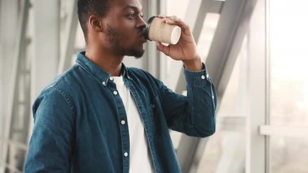 Chico viajero afroamericano bebiendo café esperando vuelo en el aeropuerto — Vídeos de Stock