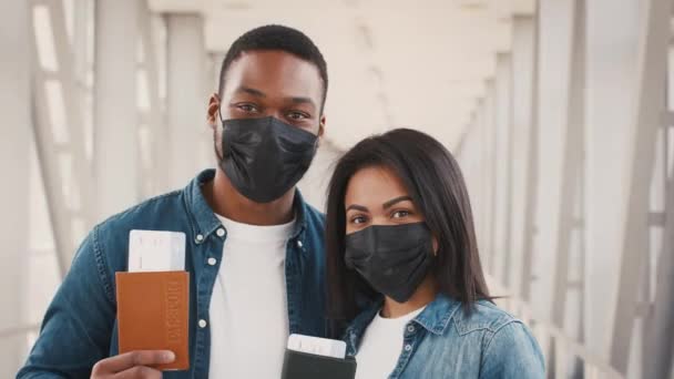 Ευτυχισμένοι Αφροαμερικανοί τουρίστες ζευγάρι που κατέχουν εισιτήρια στέκεται στο αεροδρόμιο — Αρχείο Βίντεο