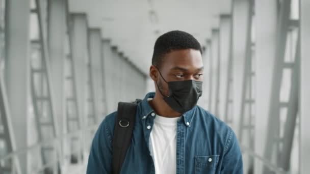 Homme voyageur noir portant un masque protecteur marchant à l'aéroport — Video