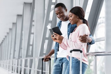 Ticket Sales Service. Black Couple Waiting For Flight Boarding At Airport Terminal