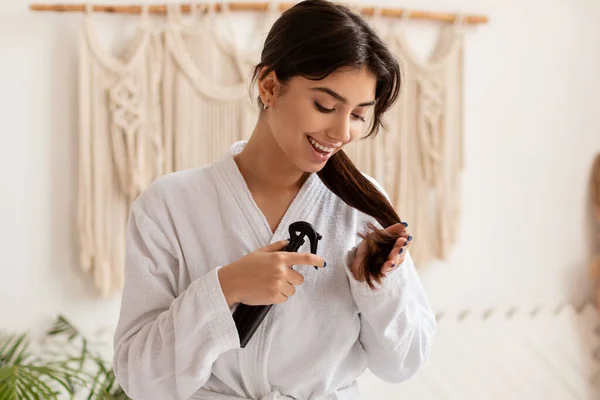 Brunette Lady Spraying Hair Caring For Split Ends In Bathroom — Stok Foto