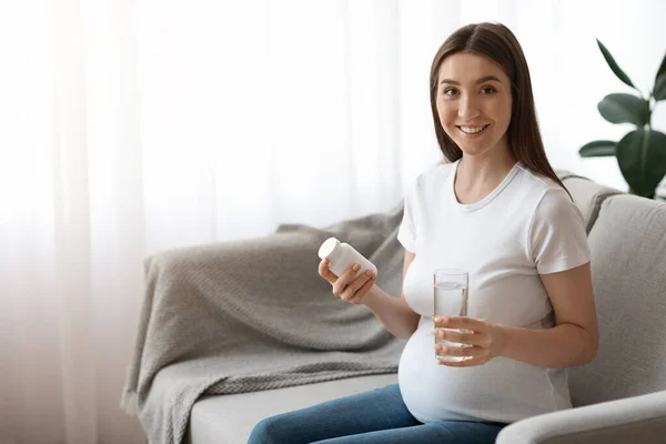 Prenatal Vitamins. Pregnant Woman Holding Jar With Pills And Glass Of Water