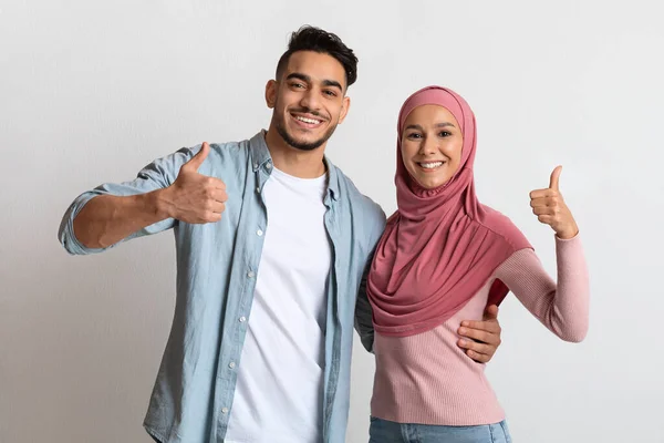 Happy Millennial Muslim Couple Embracing And Showing Thumbs Up At Camera — 스톡 사진