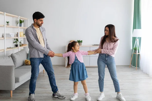 Conceito de divórcio. Pais árabes lutando por seu filho, homem louco e mulher brigando, de pé na sala de estar — Fotografia de Stock