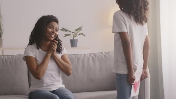 Happy Mothers Day celebration. Little african american girl congratulating her black mother with handmade postcard — Stock Video