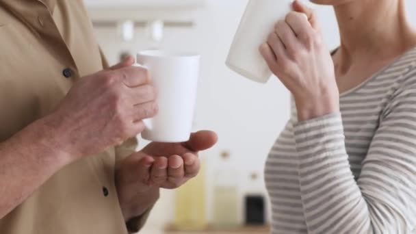 Coppia irriconoscibile bere caffè tenendo tazze in posa in cucina — Video Stock