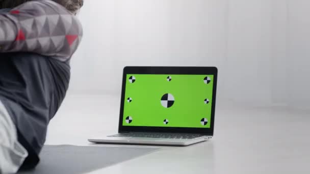 Deportista haciendo ejercicio en casa, viendo video tutorial en el ordenador portátil, pantalla clave de croma verde con marcadores de seguimiento — Vídeos de Stock