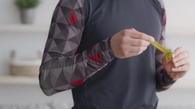 Kilo verme sonucu. Elinde bant tutan, takip eden, yavaş çekim yapan, tanınmayan sporcunun yakınına git.