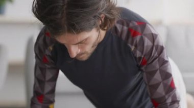 Yakın çekim, odaklanmış beyaz adam şınav egzersizi yapıyor, evde egzersiz yapıyor, ağır çekim.