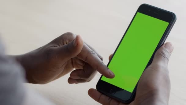 Close up shot of black guy scrolling touchscreen of modern smartphone, gadget com tela de tecla chroma verde — Vídeo de Stock