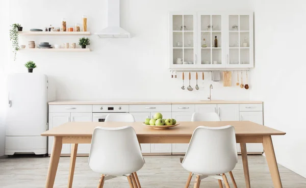 Fényes új konyhabútor. Polcok edényekkel, evőeszközökkel, kis hűtőszekrénnyel, székekkel és asztallal skandináv stílusban — Stock Fotó
