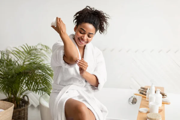 Afrikaanse dame toepassen crème op ellebogen verzorging voor de huid Indoor — Stockfoto