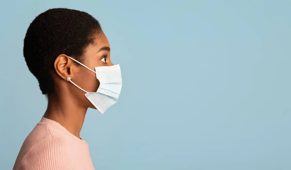 바이러스는 예방 개념을 널리 퍼뜨린다. 의료용 마스크를 착용하는 흑인 여성의 프로필 샷 — 스톡 사진