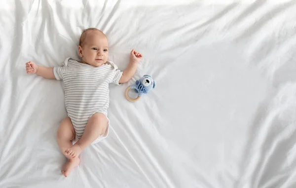 Çocuk Bakımı Konsepti. Yatakta uzanan sevimli yeni doğan bebek manzarası — Stok fotoğraf