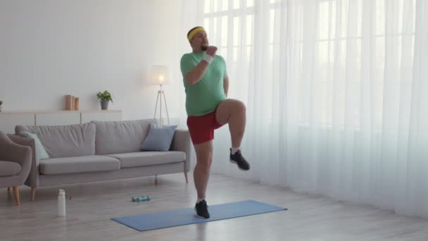 Sporteinsteiger. Lustige reife Mann in Sportkleidung praktiziert aktives Cardio-Workout zu Hause, Laufen an Ort und Stelle — Stockvideo