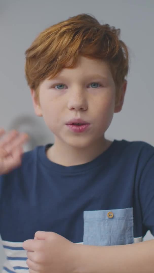 红头发小男孩与笔记本电脑交谈、摇头、与摄像机交流、垂直视频的凸轮式人物肖像 — 图库视频影像
