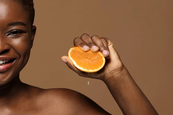 Skincare için meyve asidi. Güzel siyahi kadın taze taze portakal eziyor. — Stok fotoğraf