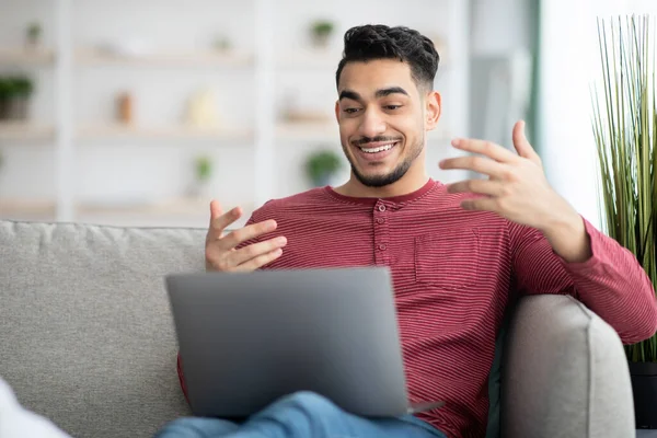 Glücklich muslim guy having online party via laptop — Stockfoto