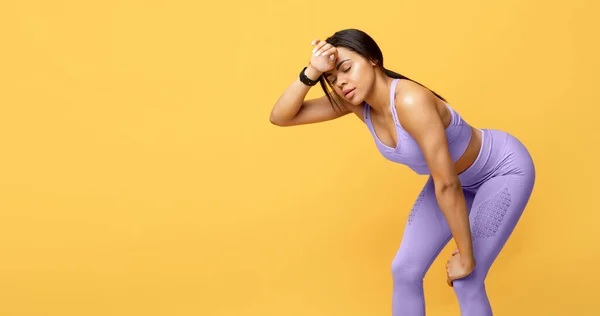 Zware training. Uitgeputte zwarte vrouw moe van het trainen vegen zweet van voorhoofd, gele achtergrond, lege ruimte — Stockfoto