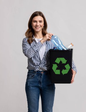 Plastik Yeniden Kullanım. Boş şişelerle dolu siyah konteynır taşıyan Milenyum Kadını