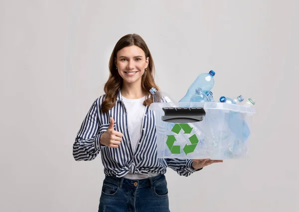 Mülltrennung. Lächelnde junge Frau trägt Container mit Plastikflaschen zum Recycling — Stockfoto
