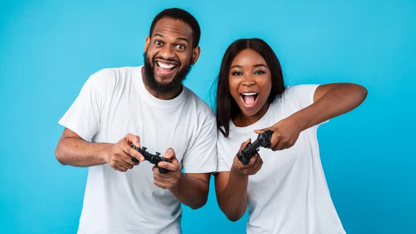 Aufgeregtes afroamerikanisches Paar spielt Videospiele mit Steuerknüppeln — Stockfoto