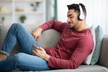 Rahat Arap adam cep telefonundan video izliyor.