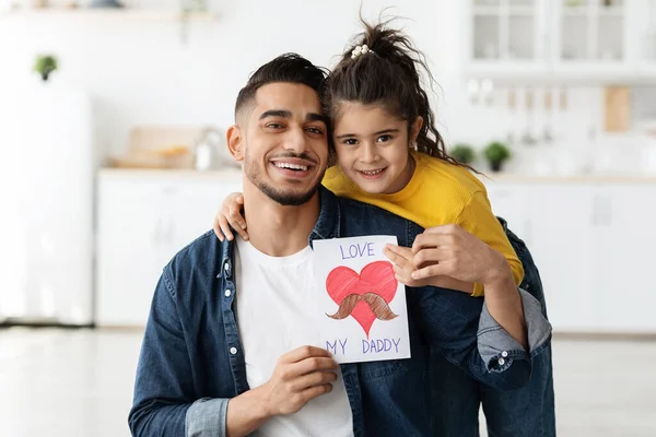 Journée internationale des pères. Petite fille mignonne surprenant son père arabe avec carte de vœux — Photo