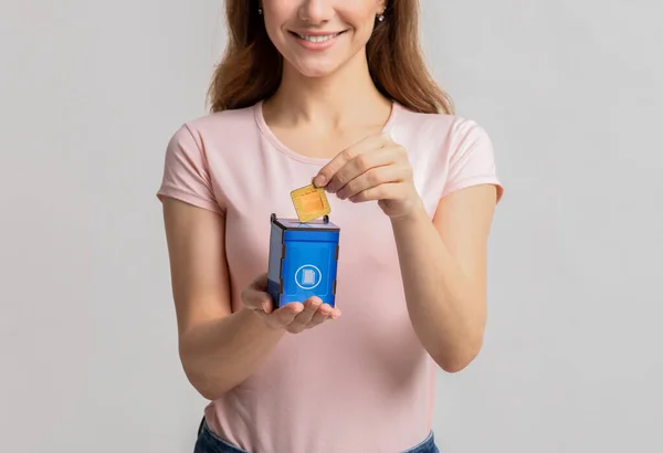 Lady poniendo la tarjeta con el icono de la bolsa de papel en el contenedor de basura de juguete azul —  Fotos de Stock