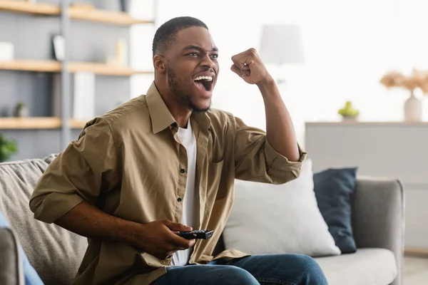 Joyful negru tip vizionarea sport joc pe TV strigăte în interior — Fotografie, imagine de stoc
