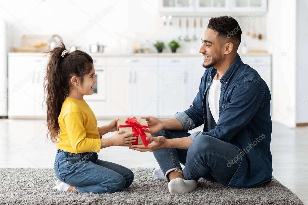 Adorable Little Arab Girl Giving Present To Dad, Greeting With Fathers Day