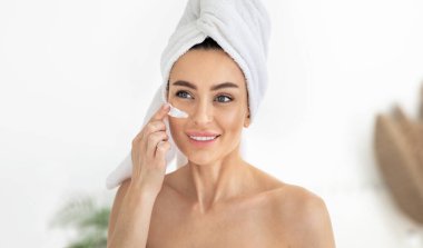 Güzel genç bir kadın taze deri için maske yapıyor. Kadın güzellik yüz bakımı, yüz bakımı.