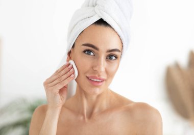 Makyaj çıkarıcı. Sünger ve mikiler suyu olan bir kadın. Cilt bakımı ve güzellik