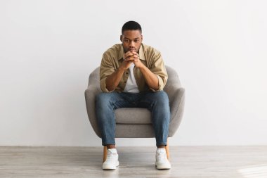 Düşünceli Afrikalı Adam Gri Arkaplanda Sandalyede Otururken Düşünüyor