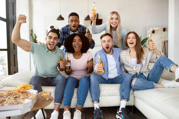 Gruppe junger Freunde mit Snacks und Bier schaut Fußballspiel im Fernsehen und feuert ihre Lieblingsmannschaft zu Hause an — Stockfoto