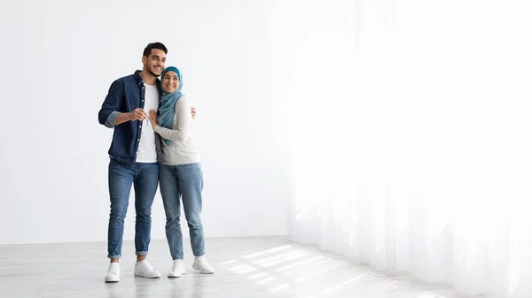 Šťastný muslimský pár s klíčem stojící v prázdném bytě — Stock fotografie
