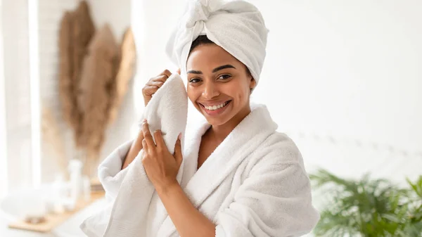 Felice afro-americano femminile asciugatura viso con asciugamano in bagno — Foto Stock